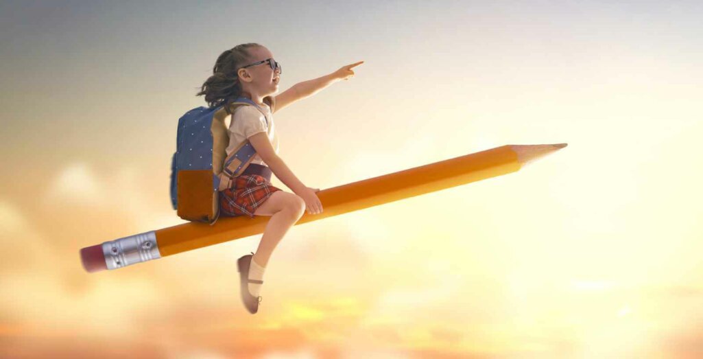 Back to school! Happy cute industrious child flying on the pencil on background of sunset sky.