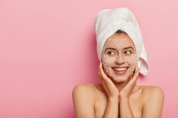 woman exfoliating her face with face scrub