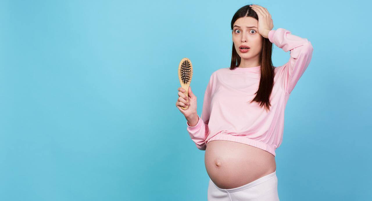 upset, young scared pregnant girl holds a comb in her hands, loses her hair during pregnancy