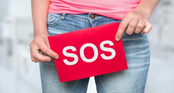 Woman with incontinence problem with SOS on paper - urinary incontinence concept