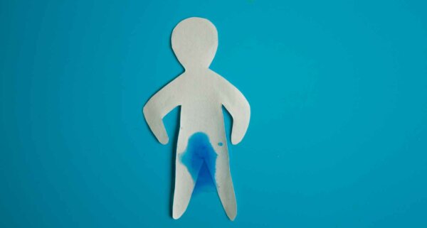 Urinary incontinence concept. Wet paper person. Blue background