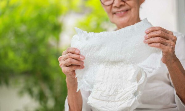 Happy smiling asian senior woman showing disposable diaper for adul