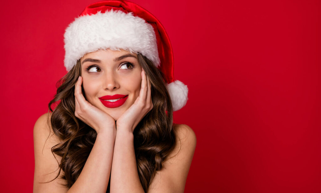 woman poses wearing a christmas cap
