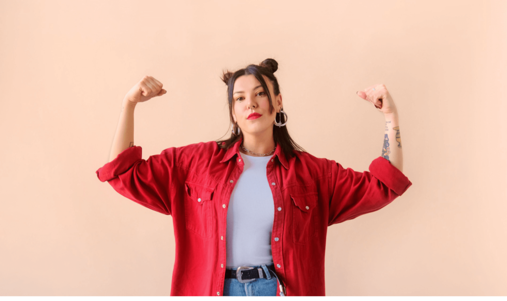 Strong powerful stylish woman with tattoo, raises arms and shows biceps. Feminism and women power