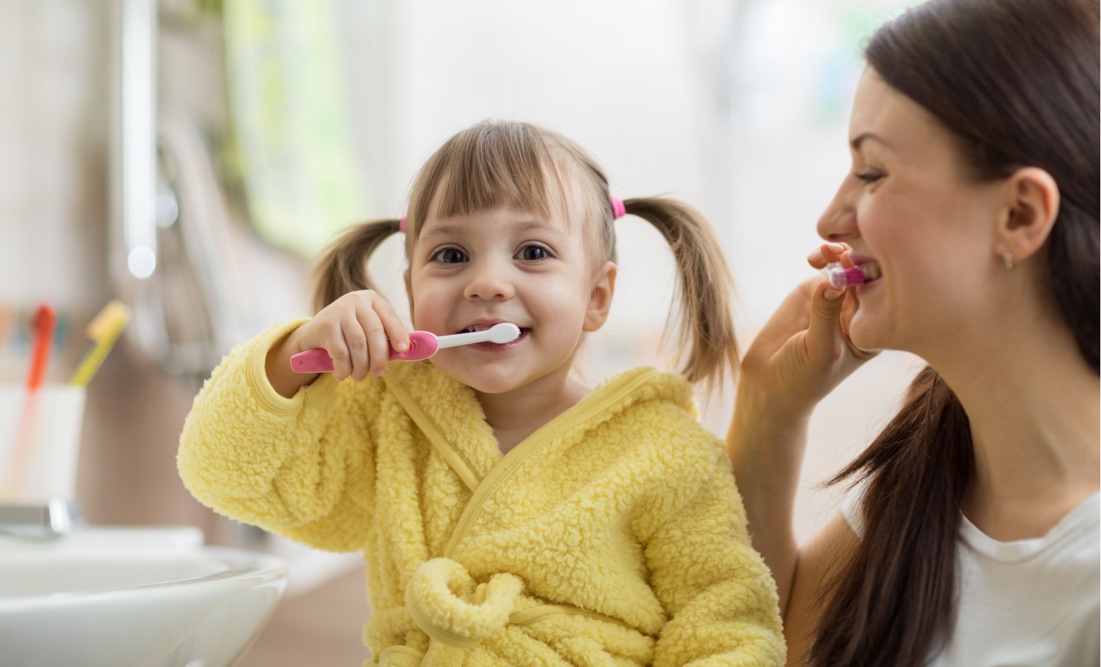 Όμορφη μητέρα και η κόρη του παιδιού βούρτσισμα των δοντιών στο μπάνιο
