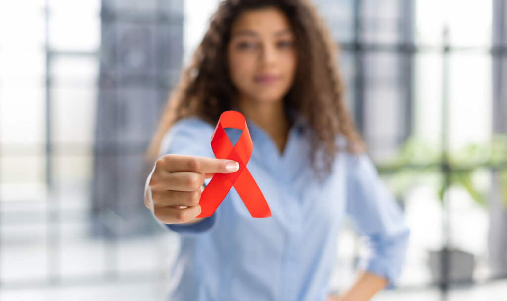 Woman holding red ribbon for december world aids day. Healthcare concept