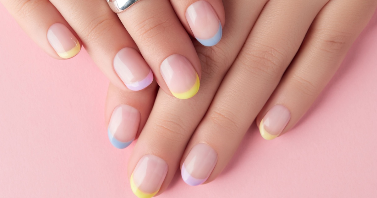 Close up manicured womans hands on pink background