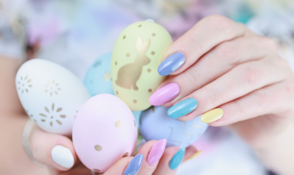 Γυναικεία χέρια με πασχαλινά νύχια κρατούν αυγά
